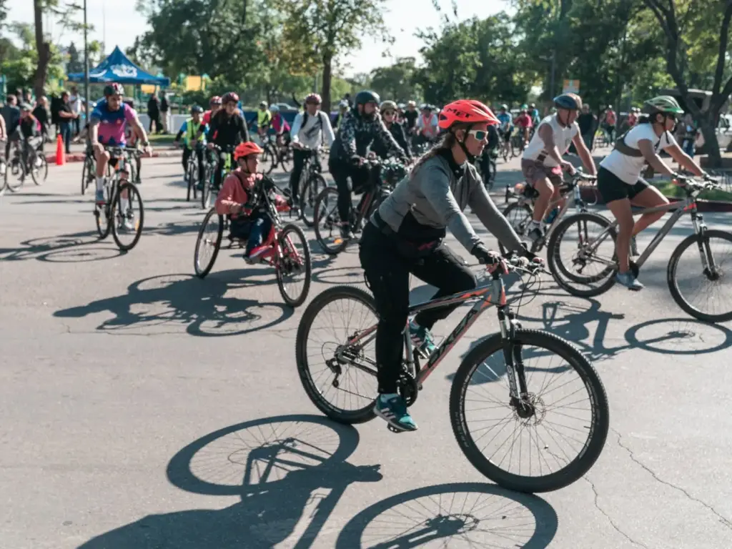 Grupo de ciclistas con casco pedaleando por una calle de la ciudad durante una salida de Ciclismo Urbano